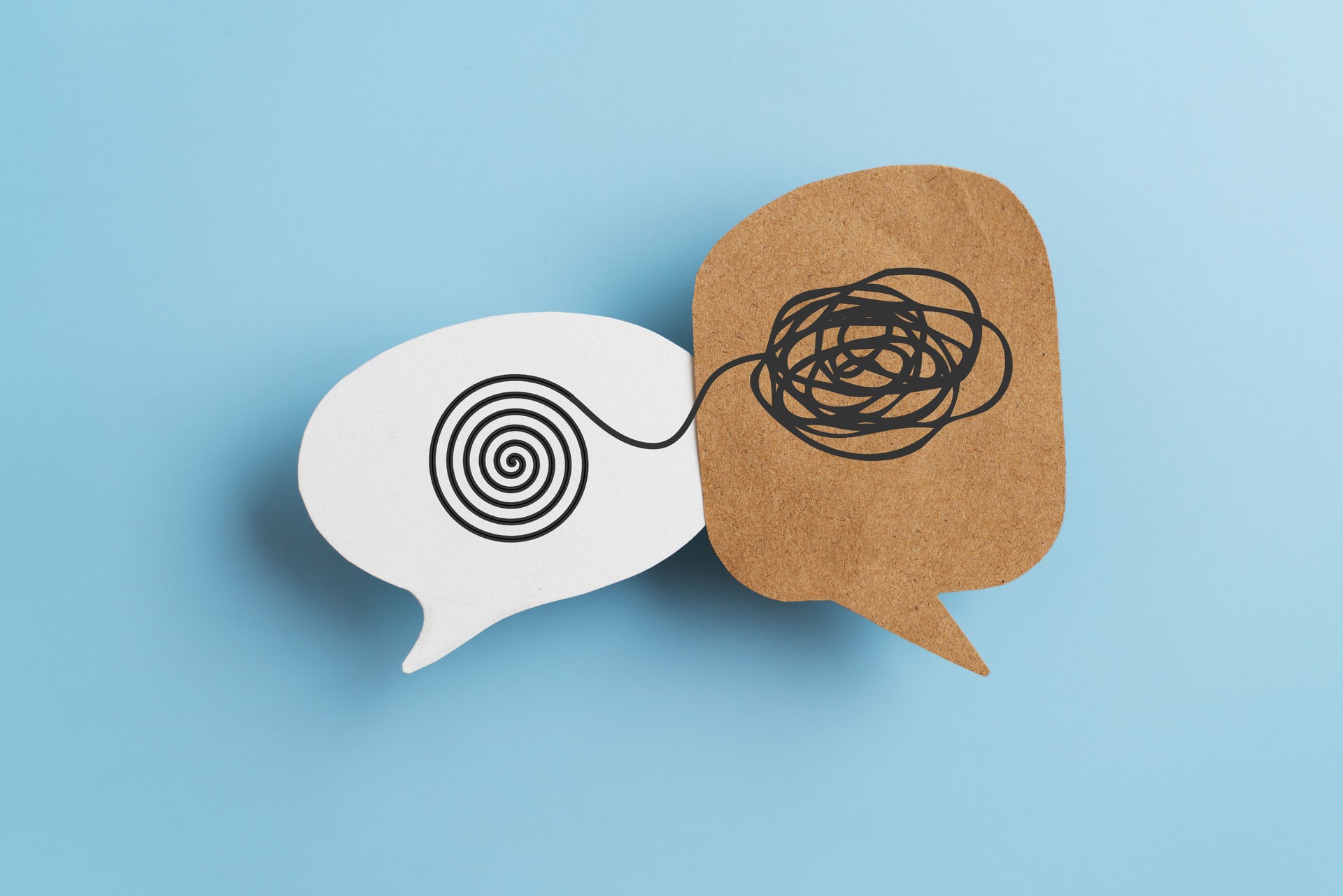 Mental health, brain disorder, World mental health day, Alzheimer, Psychology concept. Tangle of thoughts and clear line on real brown and white speech bubble paper cut with blue background